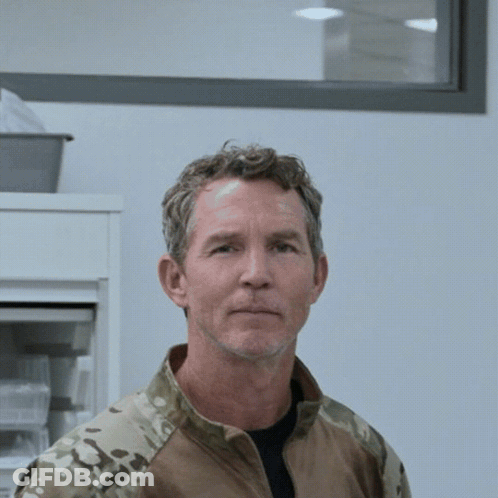 Man In Camouflage Jacket Looking At Camera GIF