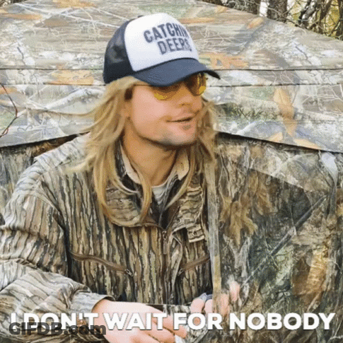 Man In Camouflage Tent Wearing Hat Saying Catchin Deer GIF