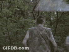 Man In Camouflage Vest Running Through Forest GIF