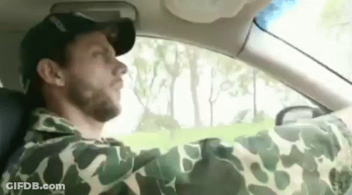 Man In Camouflage Yawning While Driving GIF