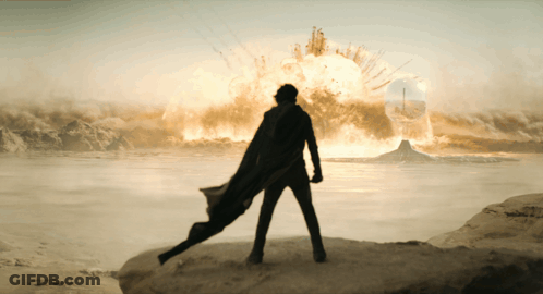 Man In Cape Facing Huge Explosion GIF