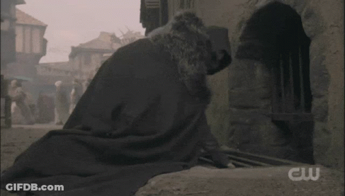 Man In Cape Walking Down Narrow Street With CW Logo GIF