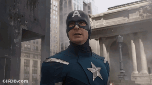 Man In Captain America Costume In Front Of Building GIF
