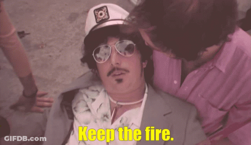 Man In Captain Hat And Sunglasses Says Keep The Fire GIF