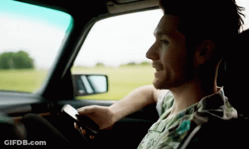 Man In Car Looking At Phone GIF