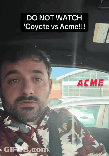 Man In Car With Acme Sign GIF