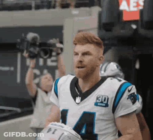 Man In Carolina Panthers Jersey Holding Helmet GIF