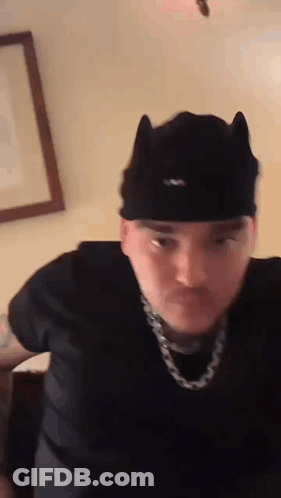 Man In Cat Ear Hat And Chain Making Funny Face GIF