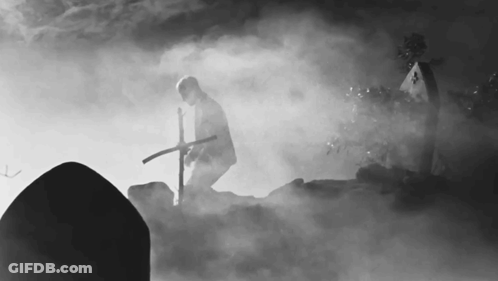 Man In Cemetery Holding Cross GIF