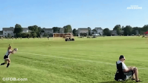 Man In Chair Watches Girl Throw Frisbee GIF