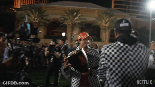 Man In Checkered Jacket Holding Trophy GIF