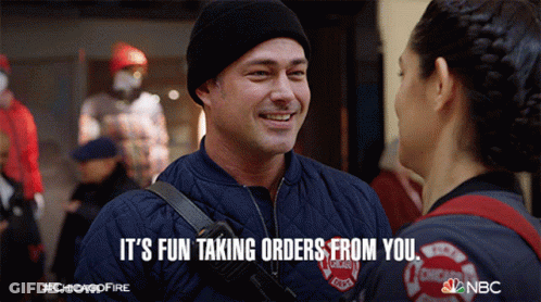 Man In Chicago Fire Department Jacket Talking To Woman GIF