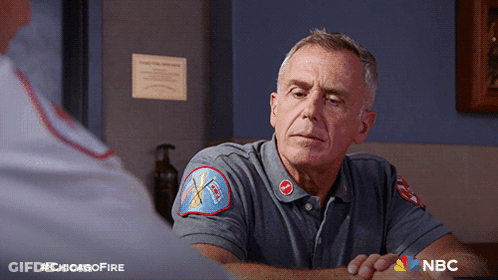 Man In Chicago Fire Uniform Sitting At Table GIF
