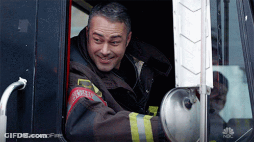 Man In Chicago Fire Uniform Smiling In Truck GIF