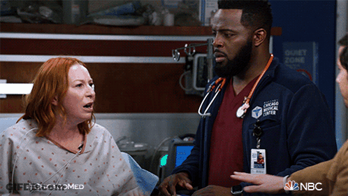 Man In Chicago Medical Center Jacket Talks To Woman GIF