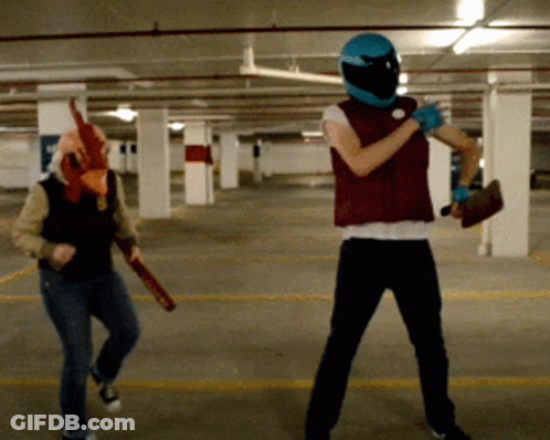 Man In Chicken Mask Next To Man In Blue Helmet GIF