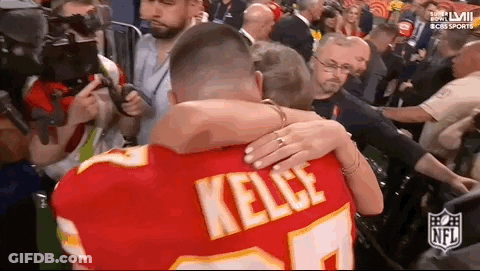 Man In Chiefs Jersey Hugging Woman GIF