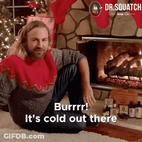 Man In Christmas Sweater By Fireplace Saying It's Cold Out There GIF