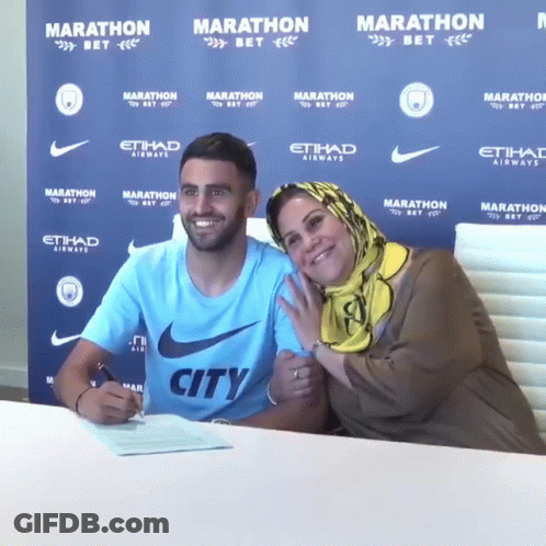 Man In City Shirt Signing Document With Mother GIF