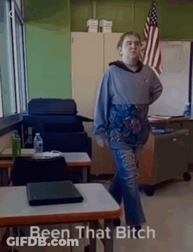 Man In Classroom With Laptop And Flag GIF