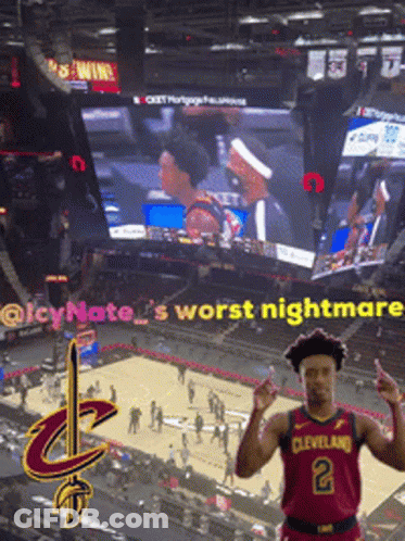 Man In Cleveland Jersey In Front Of Large Screen GIF