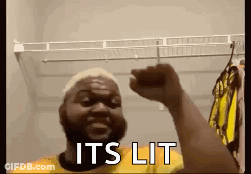 Man In Closet With Fist In The Air Saying It's Lit GIF