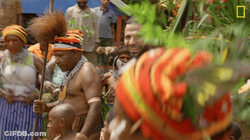 Man In Colorful Hat In Crowd With National Geographic Logo GIF