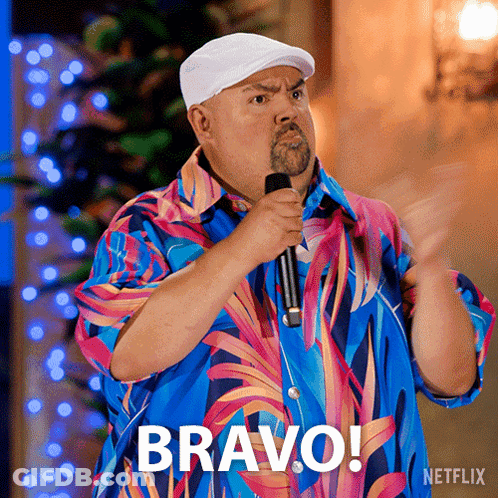Man In Colorful Shirt Holding Microphone With Bravo Above GIF