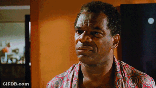 Man In Colorful Shirt Looking At Camera GIF