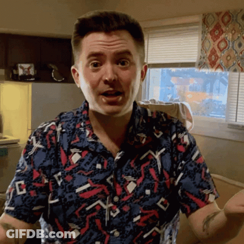 Man In Colorful Shirt Making Funny Face In Front Of Window GIF