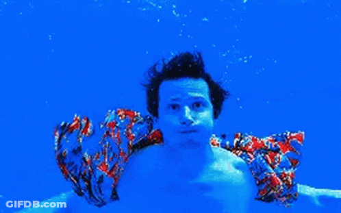 Man In Colorful Shirt Swimming Underwater In Blue Pool GIF