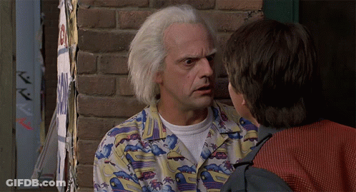 Man In Colorful Shirt Talking To Another Man In Front Of Brick Wall GIF