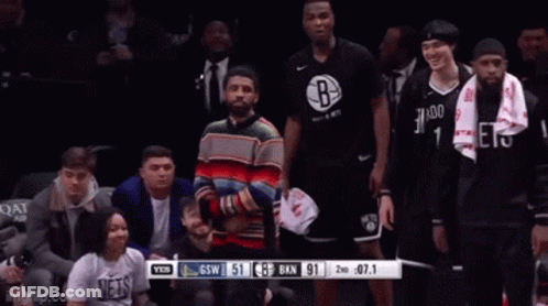 Man In Colorful Sweater In Front Of Brooklyn Nets GIF