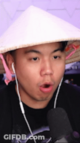 Man In Conical Hat Talking Into Microphone GIF