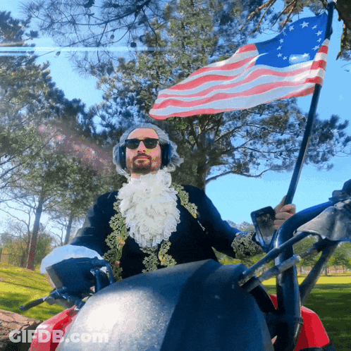 Man In Costume Holding American Flag Riding Golf Cart GIF