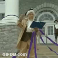 Man In Costume Holding Book In Front Of Building GIF