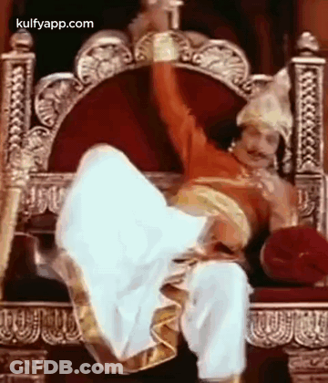 Man In Costume Sitting On Throne With Legs In Air GIF