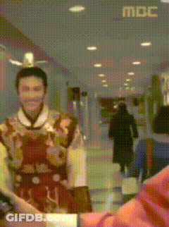 Man In Costume Standing In Hallway With MBC On Ceiling GIF