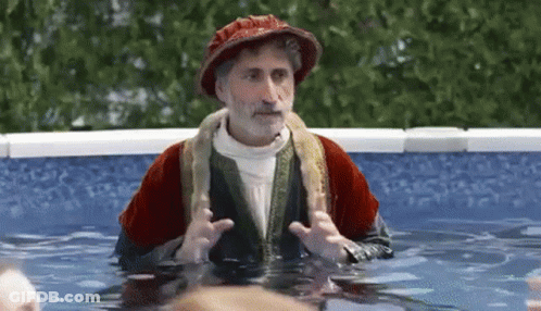 Man In Costume Standing In Pool With Snake Around Neck GIF