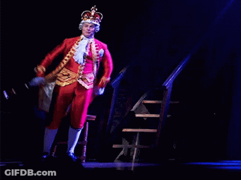 Man In Costume With Crown Sitting On Chair GIF