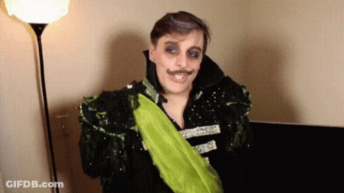 Man In Costume With Green Sash GIF