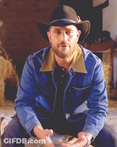 Man In Cowboy Hat And Denim Jacket Sitting GIF