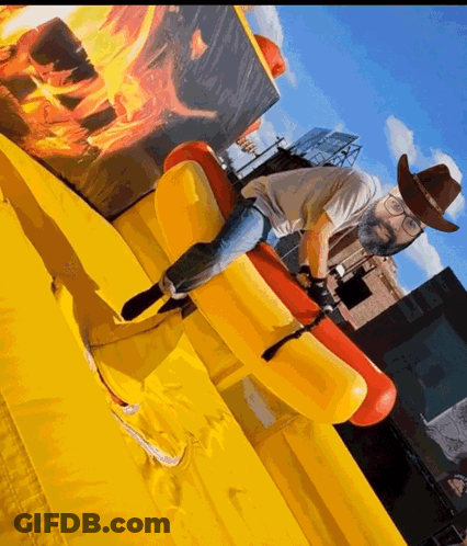 Man In Cowboy Hat And Glasses Riding Inflatable Horse GIF
