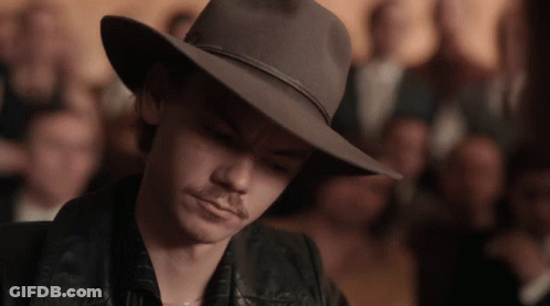 Man In Cowboy Hat And Leather Jacket Looking Down GIF