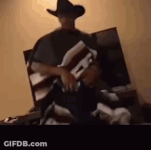 Man In Cowboy Hat And Poncho Sitting GIF