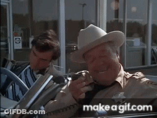 Man In Cowboy Hat Holding Gun In Front Of Make A Gitcom Sign GIF