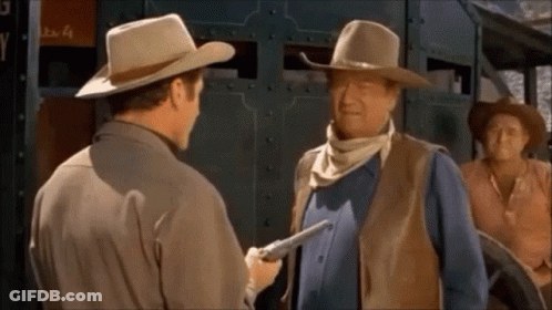 Man In Cowboy Hat Holding Gun To Another Man's Chest GIF