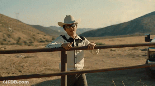 Man In Cowboy Hat Leaning On Fence GIF