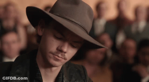 Man In Cowboy Hat Looking Down In Front Of Crowd GIF