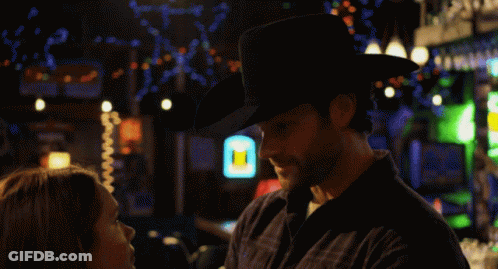 Man In Cowboy Hat Looks At Woman GIF
